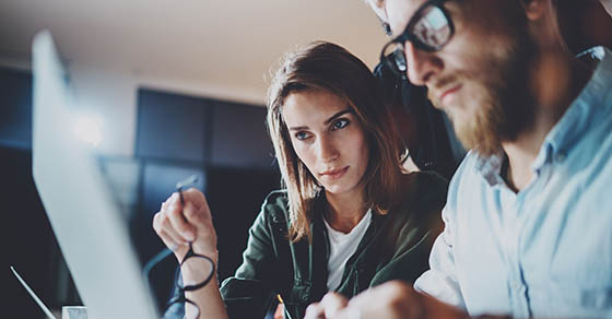 two people look at computer